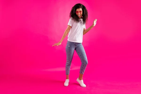 Foto de tamaño completo de las zapatillas de vestir de danza joven cool gafas camiseta jeans aislados sobre fondo rosa —  Fotos de Stock