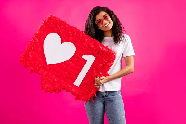 Foto de senhora milenar bonito segurar óculos de brinquedo grande desgaste t-shirt jeans isolado no fundo cor-de-rosa — Fotografia de Stock