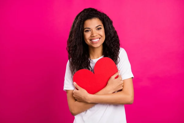 Foto de boa morena milenar senhora abraço coração desgaste branco t-shirt isolado no fundo cor-de-rosa — Fotografia de Stock