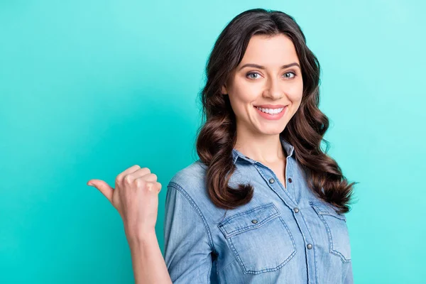 Фото молодой девушки счастливая положительная улыбка точка большой палец пустое пространство реклама совет предложить изолированных на бирюзовый цвет фона — стоковое фото