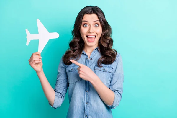 Foto de jovem animado menina feliz sorriso positivo ponto dedo avião férias vôo anúncios conselho isolado sobre fundo cor teal — Fotografia de Stock