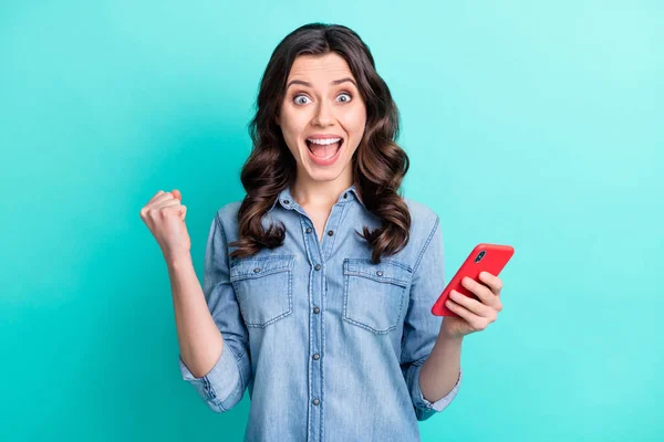 Kuva nuori innoissaan tyttö onnellinen positiivinen hymy iloita voitto nyrkit kädet käyttävät matkapuhelin eristetty sinivihreä tausta — kuvapankkivalokuva