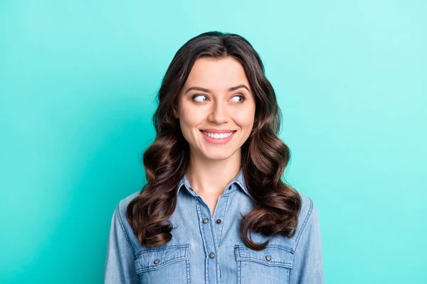 Foto de brilhante adorável jovem senhora vestido denim camisa braço sorrindo olhando espaço vazio isolado cor teal fundo — Fotografia de Stock