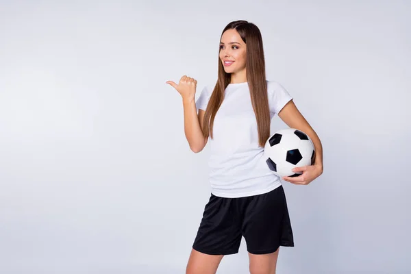 Φωτογραφία από αστεία κυρία άμεση πλευρά δάχτυλο κενό χώρο συμβουλεύει παρακολουθήσουν ποδόσφαιρο αγώνα αθλητικό μπαρ μπαρ μπαρ λαβή δερμάτινη μπάλα φορούν ποδόσφαιρο στολή t-shirt σορτς απομονωμένο λευκό χρώμα φόντο — Φωτογραφία Αρχείου