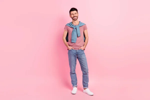 幸せな陽気な男の笑顔ホールド手ポケット隔離されたパステルピンク色の背景の完全な長さの写真 — ストック写真
