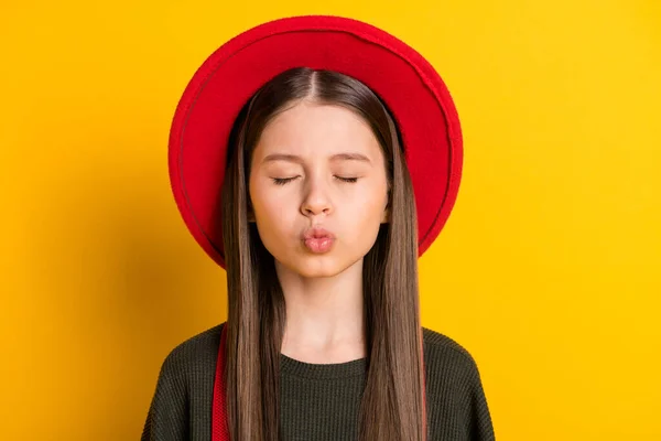 Foto portret van klein meisje met pruillip verzenden lucht kus dromerig gesloten ogen geïsoleerd op helder gele kleur achtergrond — Stockfoto