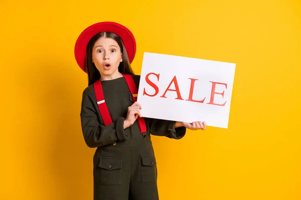 Retrato de atraente menina surpreso segurando venda placard loja shopping center centro isolado sobre cor amarela brilhante fundo — Fotografia de Stock