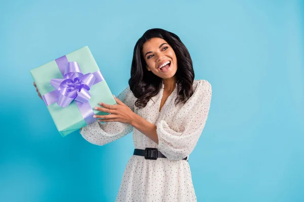 Фото молодой прекрасной позитивной улыбающейся возбужденной афро-девушки получить подарок на день рождения изолированы на синем фоне цвета — стоковое фото