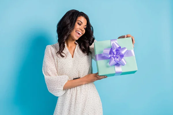 Фото молодой счастливой афро девушка получает подарок на день рождения чек-шейк окно изолированы на синем фоне цвета — стоковое фото