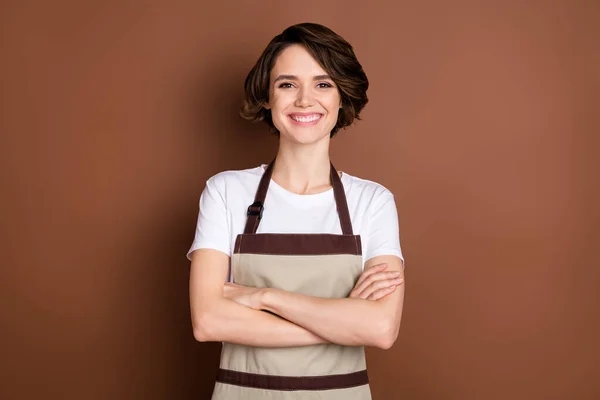 Retrato de conteúdo atraente menina alegre barista serviço de café braços dobrados isolados sobre fundo de cor marrom — Fotografia de Stock