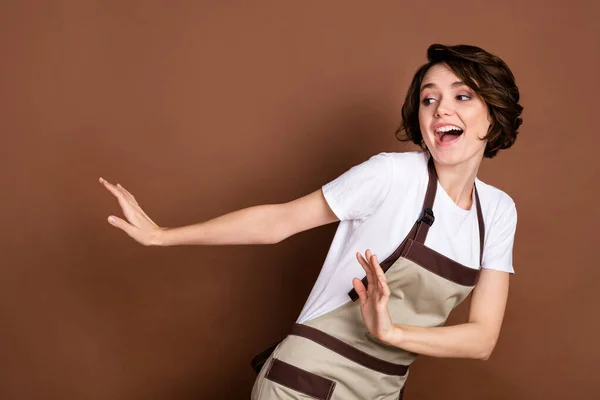Foto av glad vacker funky rolig leende kvinna barista dans ser copyspace isolerad på brun färg bakgrund — Stockfoto