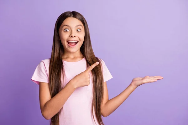 Foto di impressionato bella ragazza bruna punto tenere vuoto spazio indossare t-shirt isolato su sfondo di colore viola pastello — Foto Stock