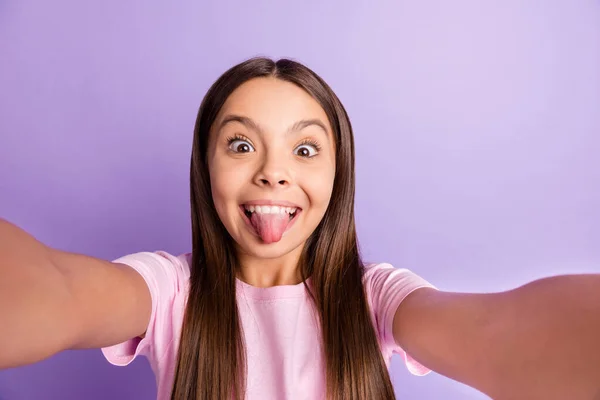 Foto de menina feliz sorriso positivo grimace tongue-out fazer selfie isolado sobre fundo de cor roxa — Fotografia de Stock