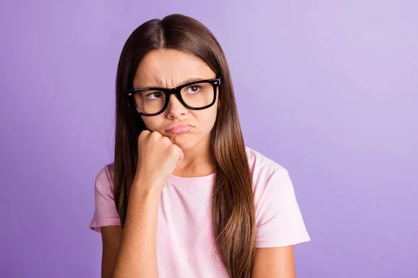 Fotografie rozrušený nešťastná mladá dívka nosit růžové tričko brýle pěst brada hledá prázdný prostor izolované fialové barvy pozadí — Stock fotografie