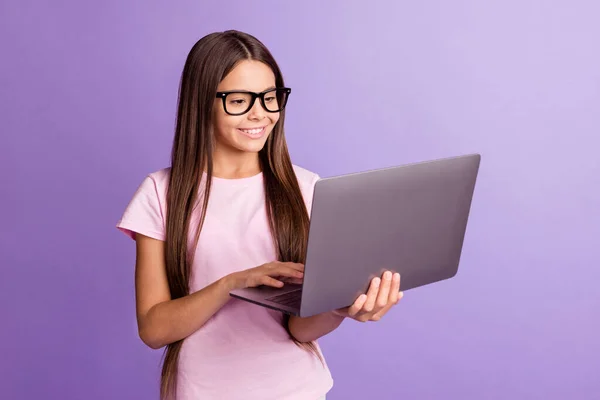 Foto di ottimista bella ragazza bruna tenere laptop indossare occhiali t-shirt isolato su sfondo di colore viola pastello — Foto Stock