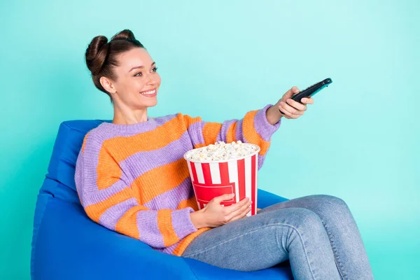 Profil sida foto av charmig vacker kvinna hålla fjärrkontroll popcorn sitta stol isolerad på teal färg bakgrund — Stockfoto