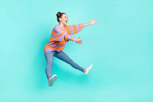 Volledige lichaamsomvang uitzicht van vrij vrolijk meisje springen knuffelen onzichtbare vriend geïsoleerd over helder teal turquoise kleur achtergrond — Stockfoto