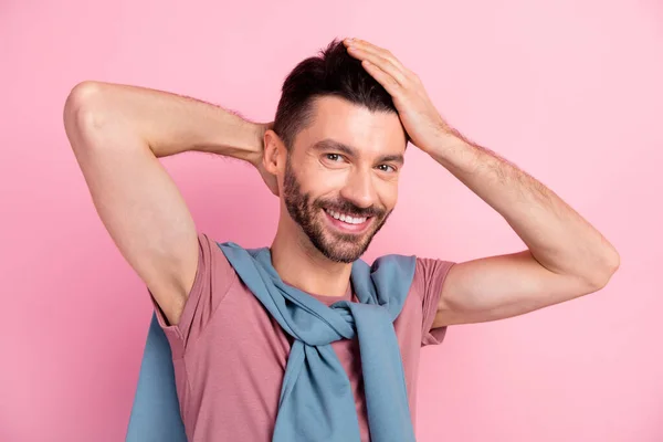 Foto di giovane bello attraente uomo allegro toccare i capelli utilizzando gel lozione isolato su sfondo di colore rosa — Foto Stock
