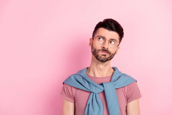 Foto di mentalità intelligente giovane uomo affascinante sguardo vuoto spazio indossare occhiali isolati su sfondo colore rosa pastello — Foto Stock