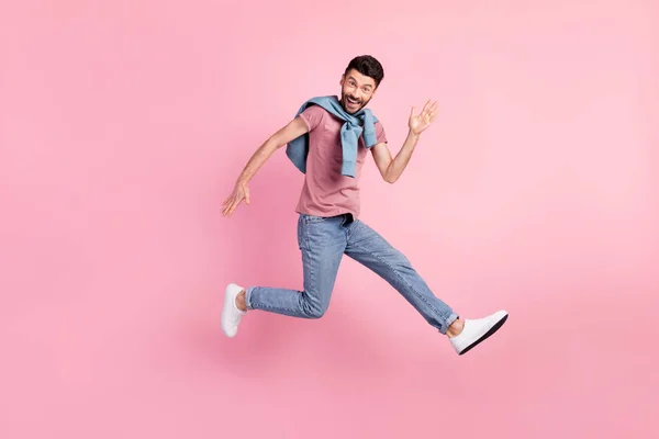 Full size foto di felice allegro sorridente bell'uomo che corre in aria dire ciao isolato su sfondo di colore rosa — Foto Stock