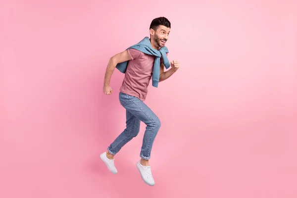 Foto lateral de perfil de tamaño completo de feliz emocionado sonriente hombre de buen humor corriendo rápido en el aire aislado en el fondo de color rosa —  Fotos de Stock