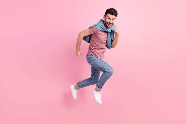 Pełnowymiarowe zdjęcie młodego funky zabawny uśmiech dobry nastrój szalony człowiek działa szybko w powietrzu odizolowany na różowym tle kolor — Zdjęcie stockowe