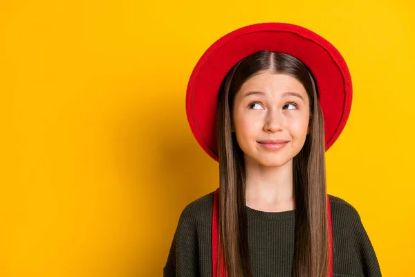 Foto portret van glimlachend schoolmeisje nieuwsgierig op zoek lege ruimte geïsoleerd op helder gele kleur achtergrond — Stockfoto