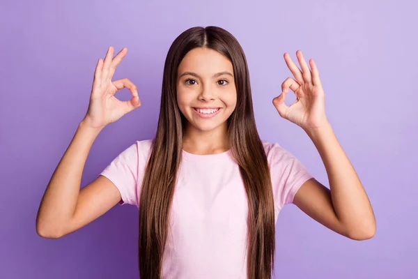 かわいいです魅力的な若い女の子の写真はピンクのTシャツを着て示すキーサイン隔離された紫色の背景 — ストック写真