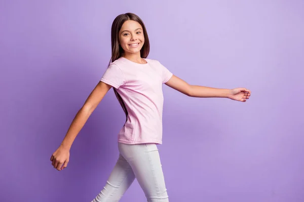 Perfil lado de la foto de la joven chica atractiva sonrisa positiva feliz ir caminar paso aislado sobre fondo de color púrpura — Foto de Stock