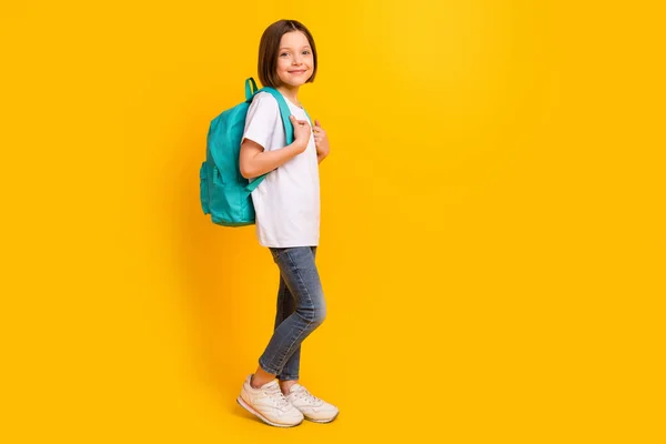 Longitud completa tamaño del cuerpo foto colegiala sonriendo usando bolso azul aislado color amarillo brillante fondo copyspace —  Fotos de Stock