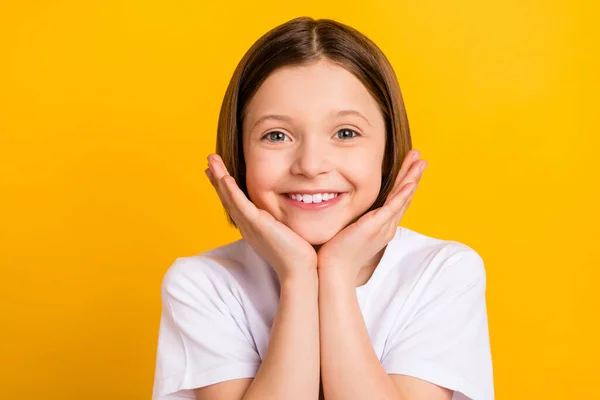 Foto porträtt liten flicka bob frisyr att hålla händerna nära ansiktet ler trevlig överlycklig isolerad ljus gul färg bakgrund — Stockfoto
