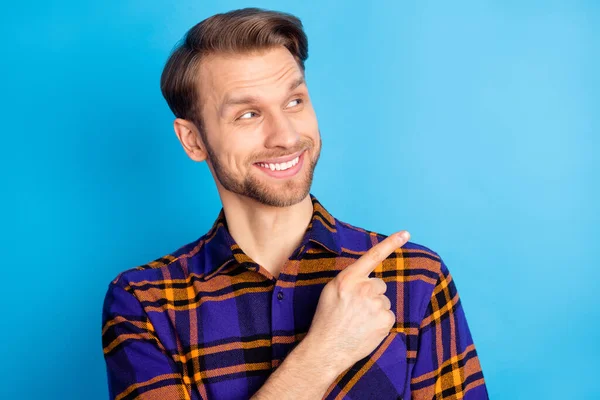 Photo de charmant jeune homme heureux regard doigt vide espace vente isolé sur fond de couleur bleue — Photo