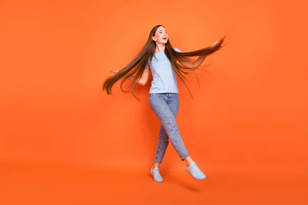 Photo pleine grandeur de jeune femme impressionnée vêtements de danse bleu t-shirt jeans isolés sur fond de couleur orange — Photo