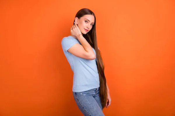 Foto de perfil de la señora agradable tacto pelo desgaste azul camiseta jeans aislados sobre fondo de color naranja —  Fotos de Stock