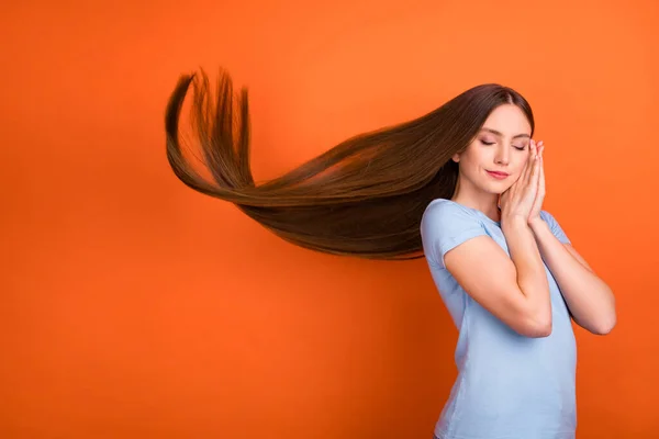 Foto de perfil de lindo peinado marrón joven dama toma de la mano dormir desgaste camiseta azul aislado sobre fondo de color naranja —  Fotos de Stock