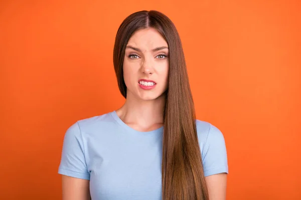 Foto de peinado marrón repugnante joven dama usar camiseta azul aislado en fondo de color naranja vivo — Foto de Stock