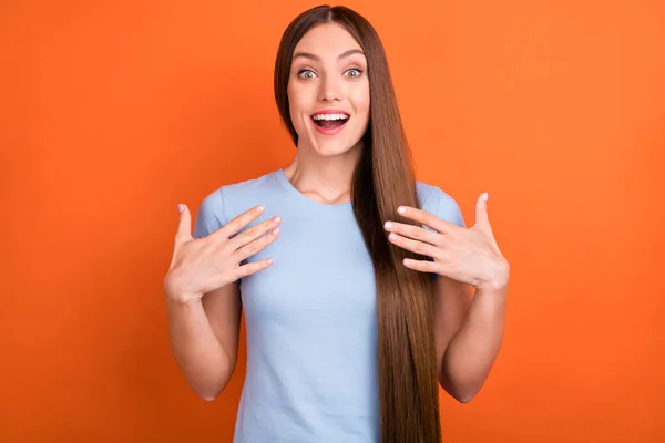 Foto di impressionato lunga acconciatura giovani mani donna indossare blu t-shirt isolato su sfondo di colore arancione vivido — Foto Stock