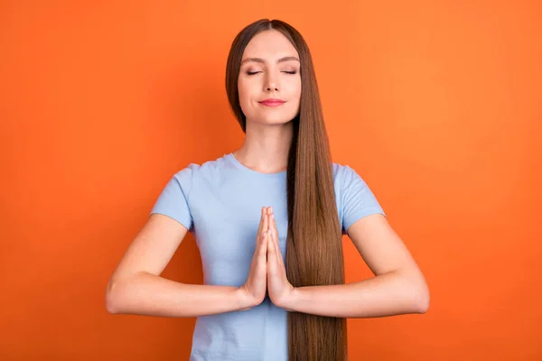 Fotografie odpočinku dlouhé vlasy tisíciletá dáma držet ruce nosit modré tričko izolované na živém oranžovém pozadí — Stock fotografie