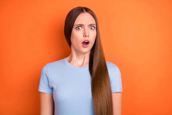 Foto von Angst lange Frisur junge Dame offenen Mund tragen blaues T-Shirt isoliert auf lebendigen orangefarbenen Hintergrund — Stockfoto