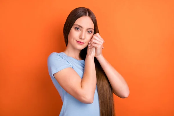 Foto de dulce peinado largo joven dama manos cara desgaste azul camiseta aislada sobre fondo de color naranja vivo — Foto de Stock
