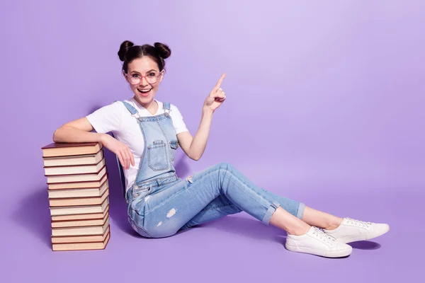 Perfil de tamaño completo lado de la foto de la joven feliz libros apuntar dedo vacío espacio anuncio promocional aislado sobre fondo de color violeta —  Fotos de Stock