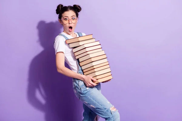 Portrait of impressed pretty person arms hold stack book open mouth look camera isolated on purple color background — Stock Photo, Image