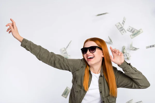 Retrato de atraente na moda alegre menina ruiva dançando salário em dinheiro caindo voando isolado sobre fundo de cor de luz branca — Fotografia de Stock