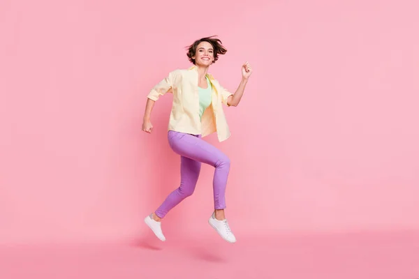 Foto de perfil em tamanho completo de otimista morena senhora salto correr desgaste camisa calças sapatilhas isoladas no fundo rosa pastel — Fotografia de Stock