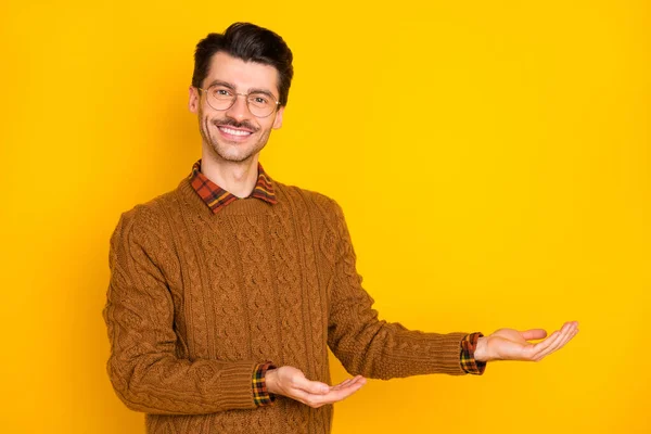 Çekici ve zeki bir adamın el ele tutuşmuş fotoğrafı. Ürün teklifini sarı arka planda izole et. — Stok fotoğraf