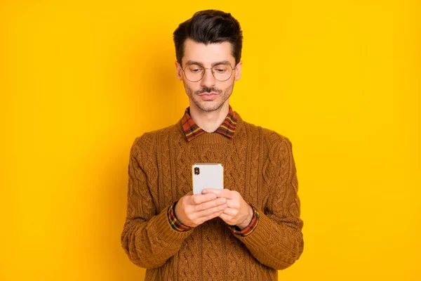 濃縮男の肖像写真電話入力コメントは黄色の色の背景に隔離されたニットプルオーバーを着用 — ストック写真