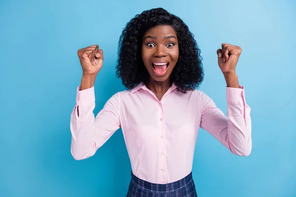 Foto av unga glada vackra glada leende afro flicka höja nävar i seger triumf isolerad på blå färg bakgrund — Stockfoto