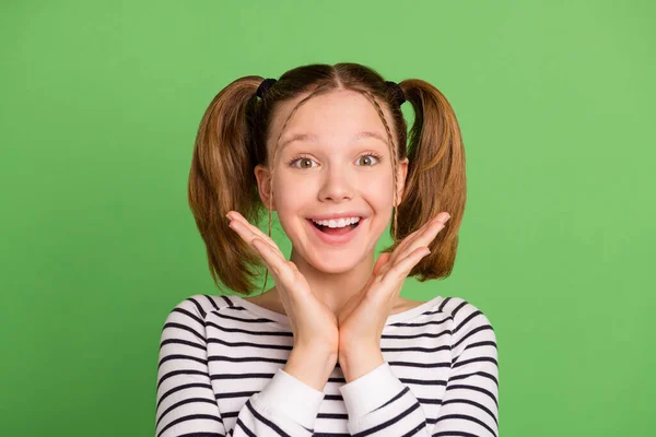 Φωτογραφία του funky ουρές hairdo μικρό κορίτσι χέρια πρόσωπο φορούν ριγέ πουλόβερ απομονώνονται σε πράσινο χρώμα φόντο — Φωτογραφία Αρχείου