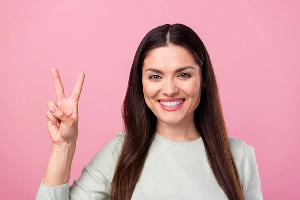 Фото привлекательной зрелой счастливой красивой женщины улыбка показать V-знак Привет лицо изолированы на розовом фоне цвета — стоковое фото