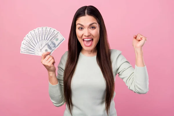 Foto di affascinante attraente giovane donna stupito vincitore tenere le mani soldi isolati su sfondo di colore rosa — Foto Stock